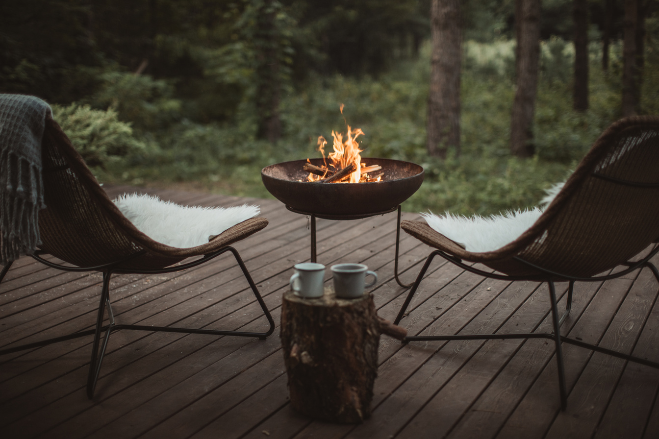 two chairs on a wooden deck with a fire pit