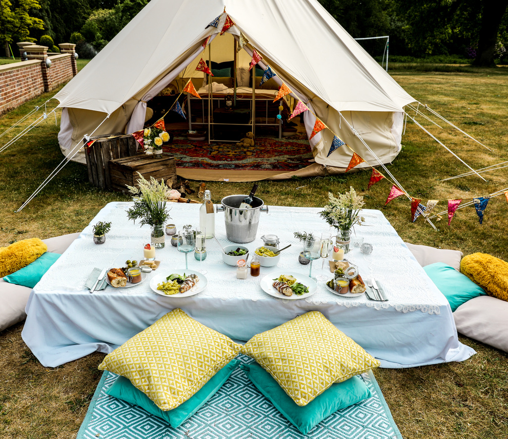 a table set up for a picnic in front of a tent